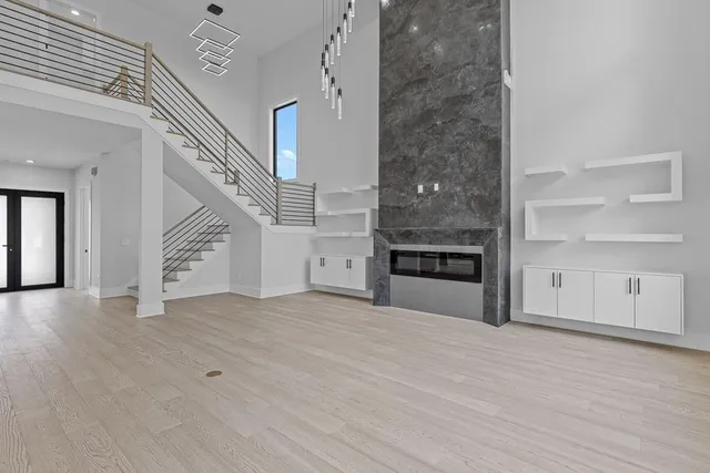 a view of an empty room with a window and cabinet