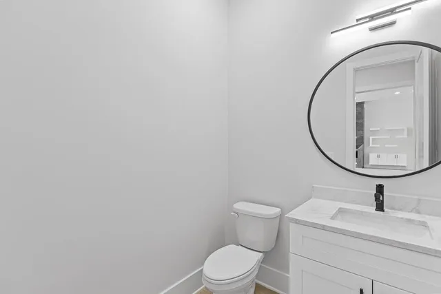 a view of an empty room with wooden floor ceiling fan and windows