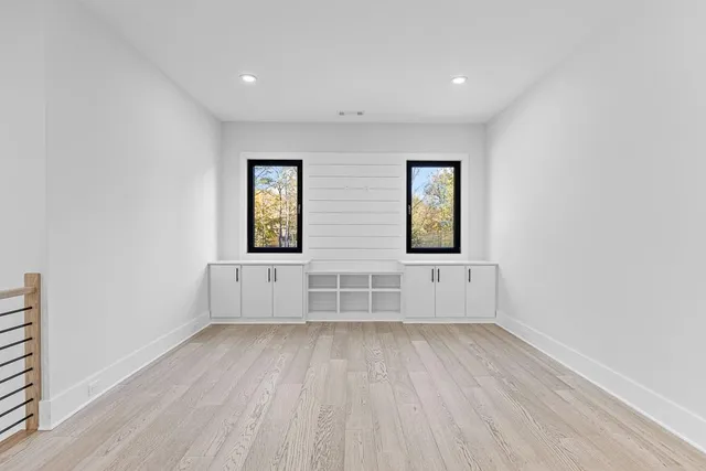an empty room with windows and closet