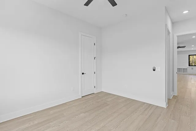 an empty room with a ceiling fan and carpet