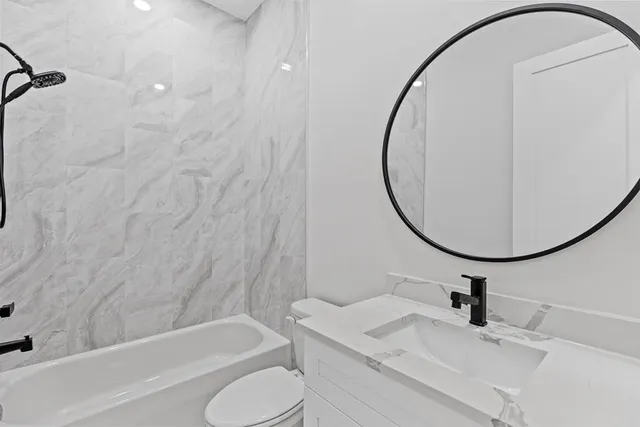 a bathroom with a toilet a sink and a mirror