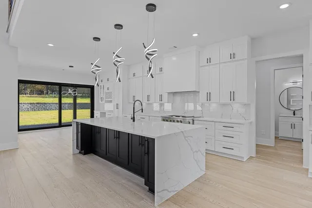 a large kitchen with cabinets a sink and stainless steel appliances