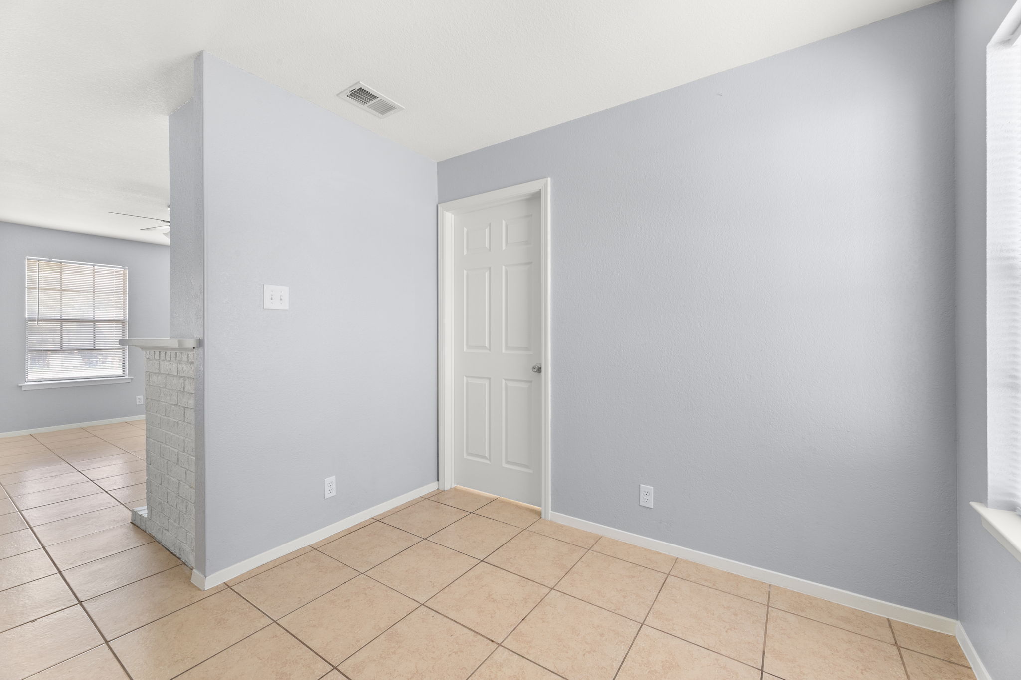 3802 Foust Trail, Unit A Georgetown, TX 78628 - Photo 10 of 34 A well-lit interior space with neutral tiled flooring and a classic paneled door.