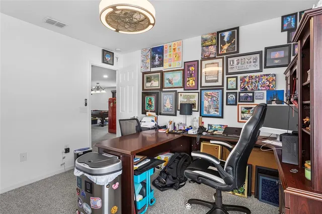 a view of a workspace with furniture and a bookshelf