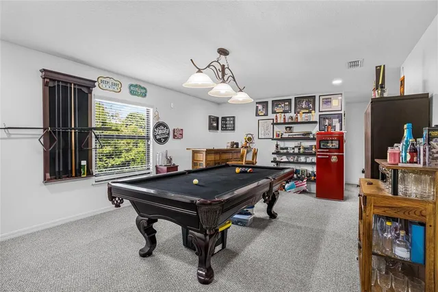 a room with furniture pool table and window