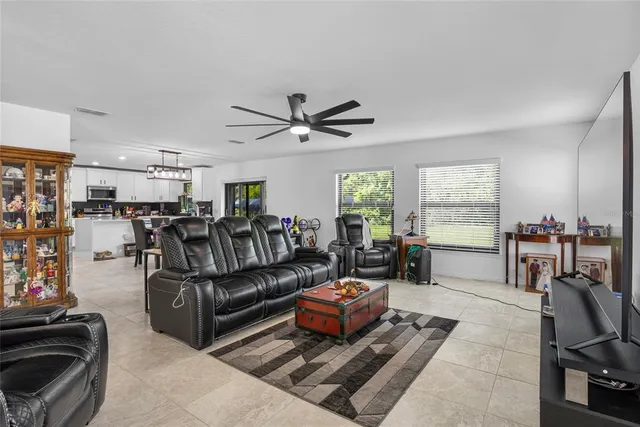 a living room with furniture ceiling fan and a window