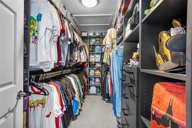 a view of walk in closet with clothes and shoes