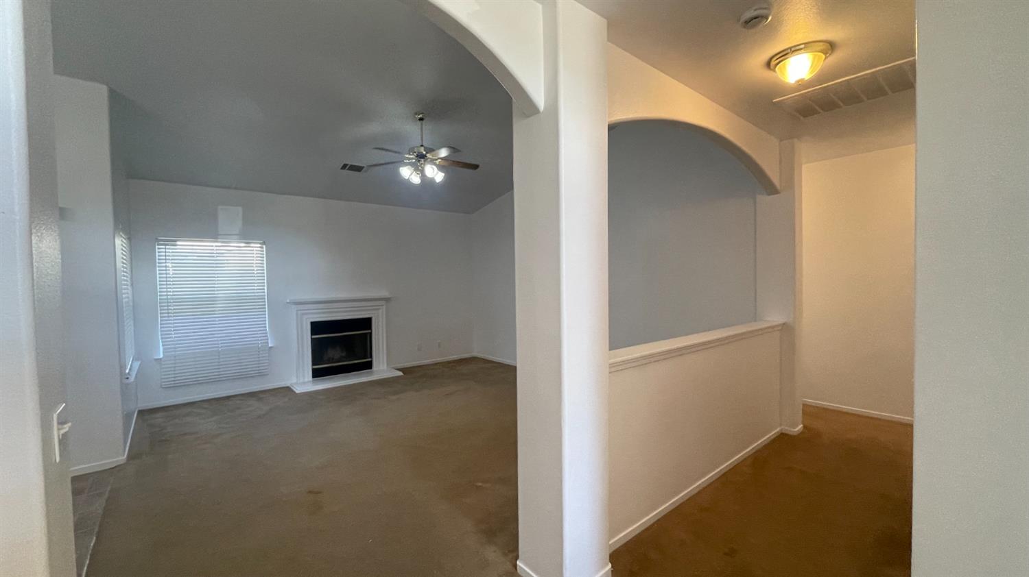 1400 Bay Street Lemoore, CA 93245 - Photo 17 of 21 a view of an empty room with chandelier fan and fire place