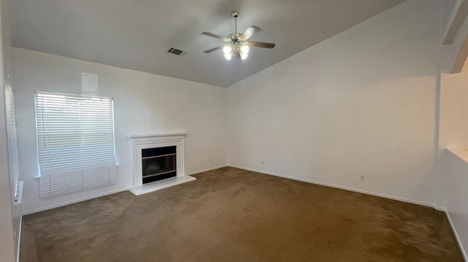 1400 Bay Street Lemoore, CA 93245 - Photo 19 of 21 an empty room with a fireplace and a ceiling fan