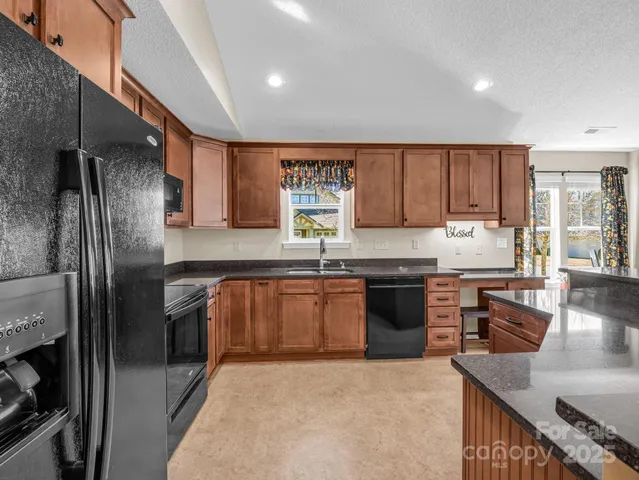 a kitchen with stainless steel appliances granite countertop a refrigerator sink and stove