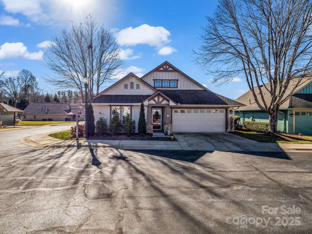 a view of a house with a yard and large tree