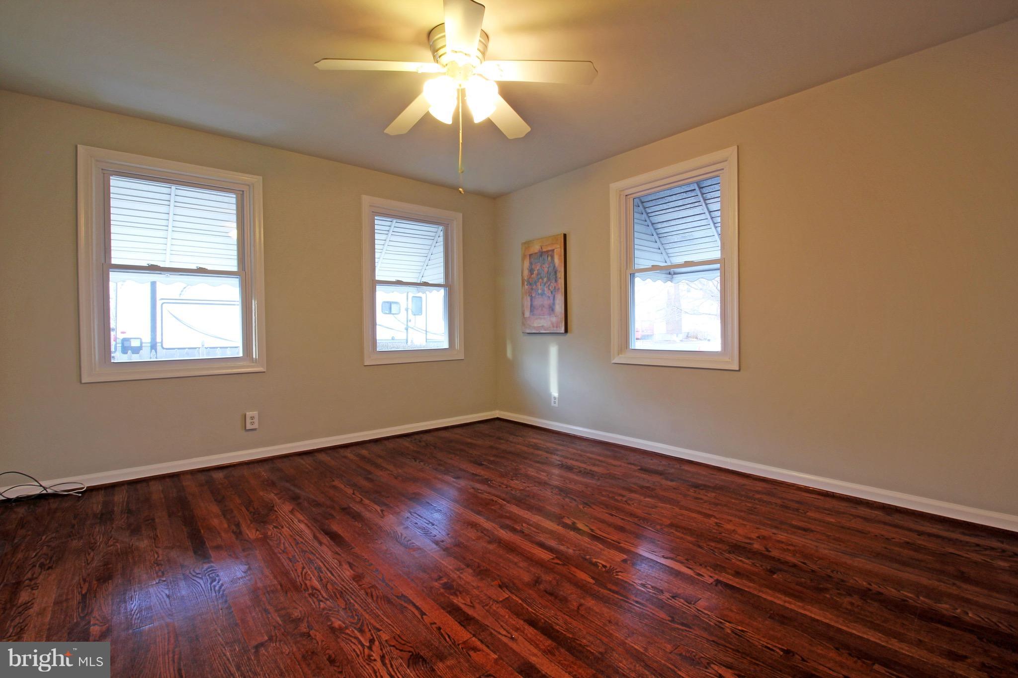 1217 Hillside Road Pasadena, MD 21122 - Photo 10 of 24 a view of an empty room with wooden floor and a window