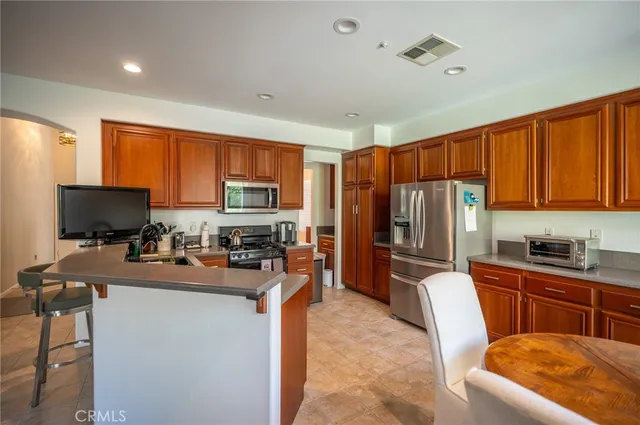 a kitchen with a refrigerator a stove top oven a sink dishwasher and wooden cabinets