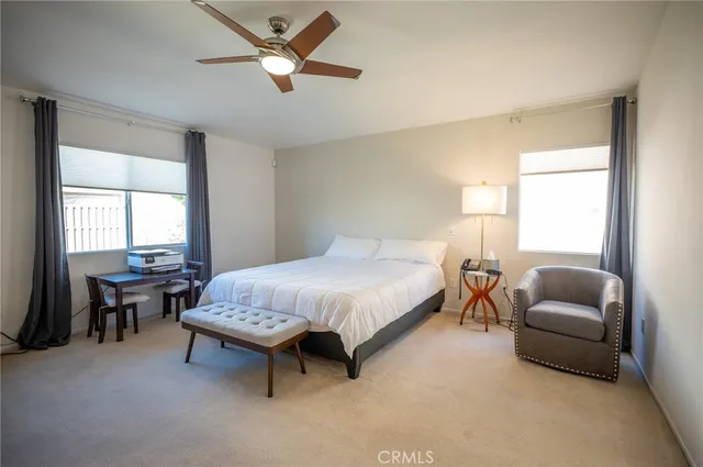 a bedroom with a bed a couch and a chandelier