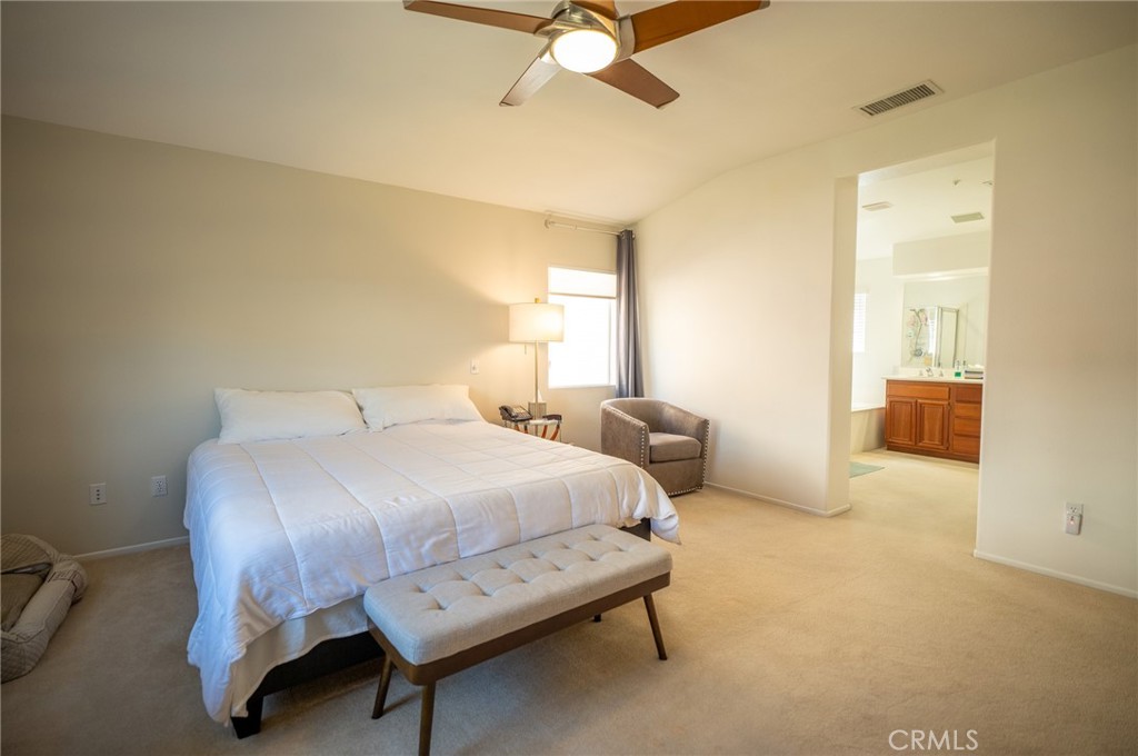 12207 Vía Santa Marta Sylmar, CA 91342 - Photo 24 of 39 a bedroom with a bed a couch and a chandelier