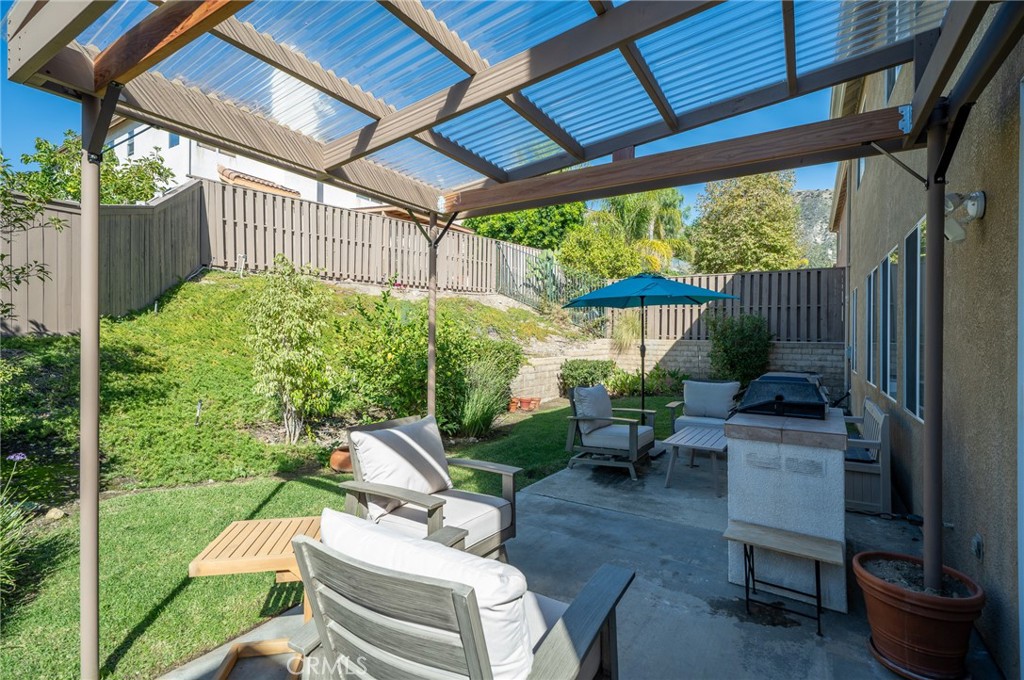 12207 Vía Santa Marta Sylmar, CA 91342 - Photo 35 of 39 a view of a patio with table and chairs potted plants with wooden floor and fence