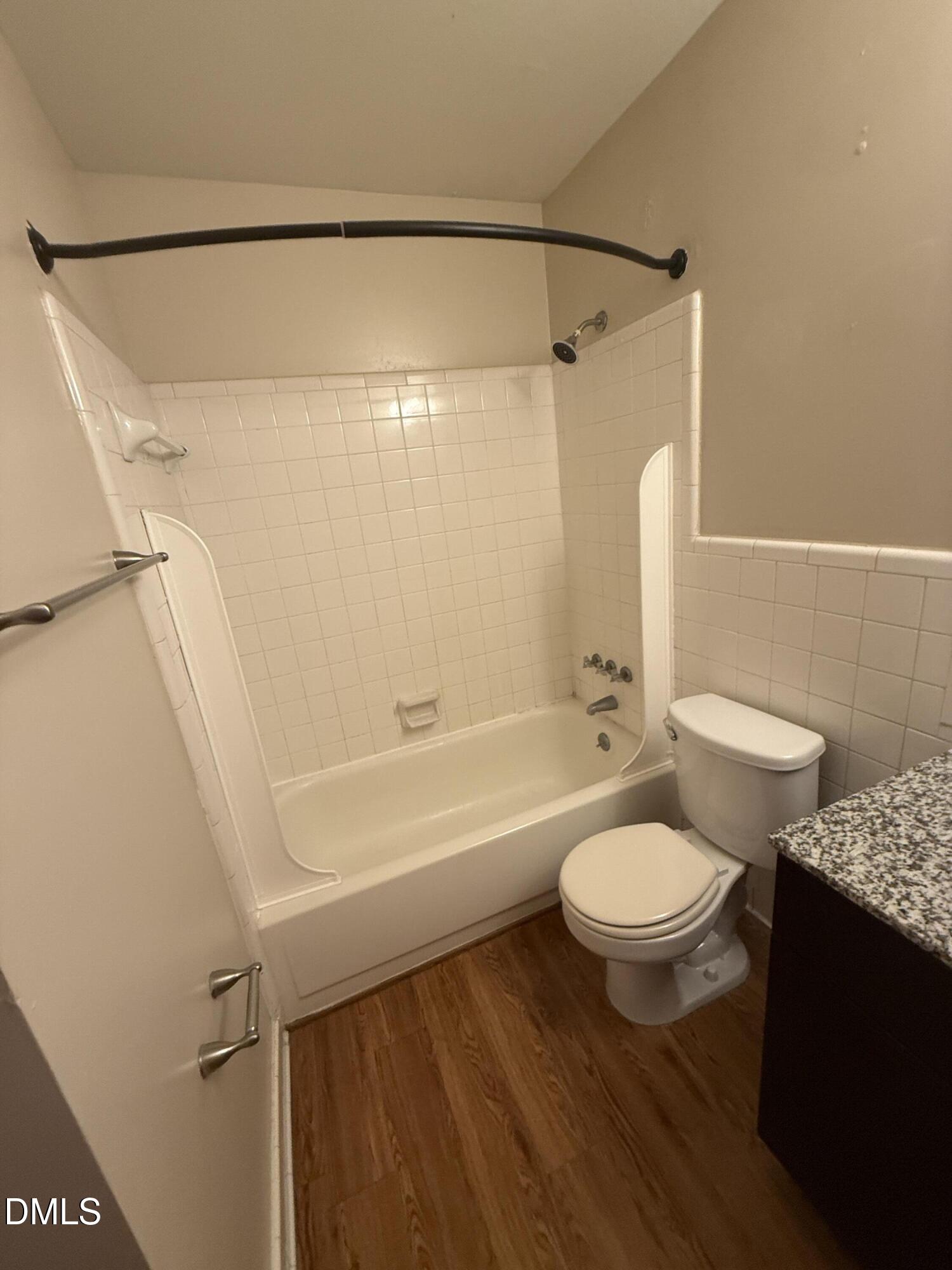2616 Noble Road, Unit D Raleigh, NC 27608 - Photo 6 of 9 a bathroom with a granite countertop sink toilet a mirror and a bathtub