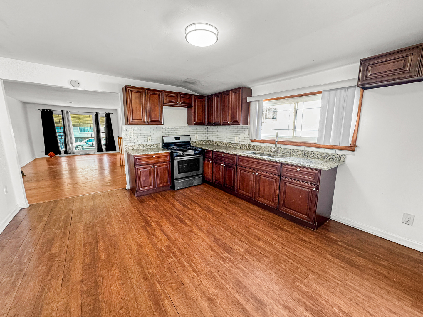 13059 Honore Street Blue Island, IL 60406 - Photo 6 of 15 a large kitchen with stainless steel appliances granite countertop a stove and wooden floor