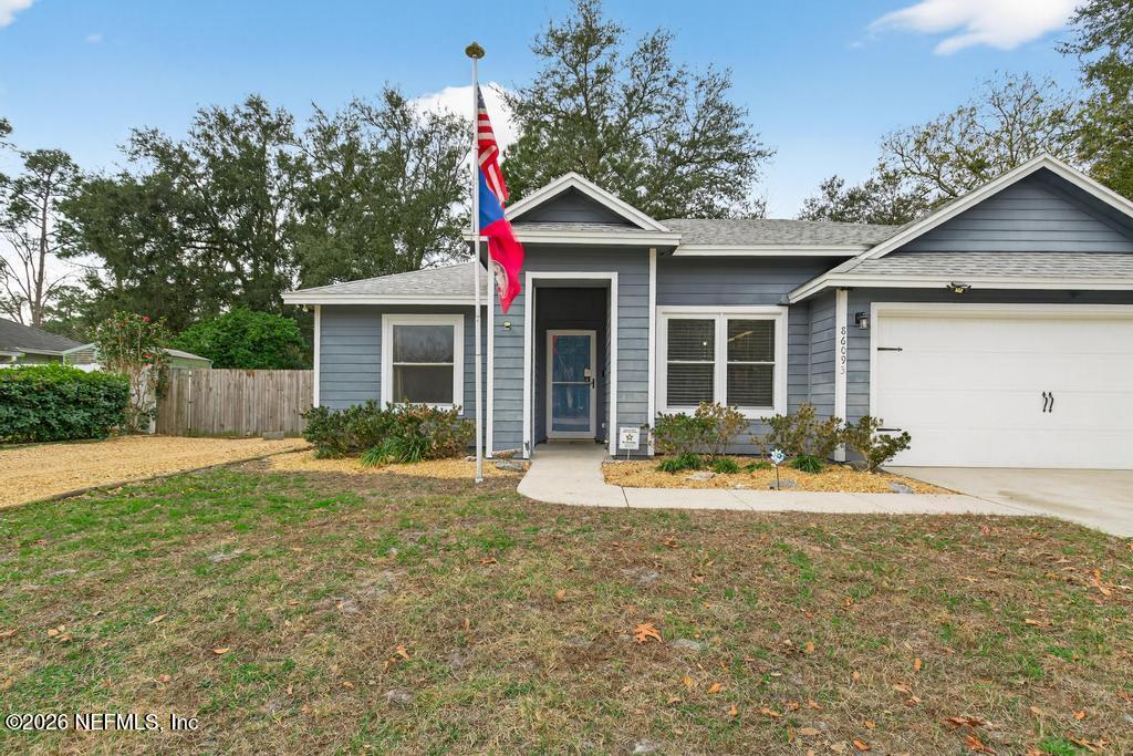 86093 Santa Barbara Street Yulee, FL 32097 - Photo 11 of 51 a front view of a house with a yard and garage