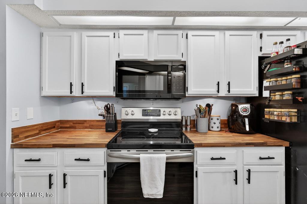 86093 Santa Barbara Street Yulee, FL 32097 - Photo 20 of 51 a kitchen with stainless steel appliances granite countertop a stove a microwave and cabinets