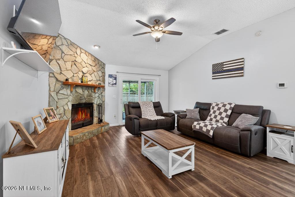 86093 Santa Barbara Street Yulee, FL 32097 - Photo 24 of 51 a living room with furniture a fireplace and a large window