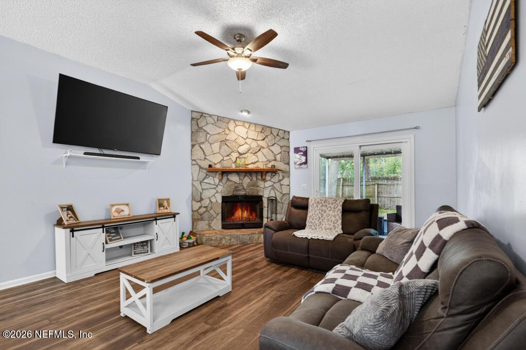 86093 Santa Barbara Street Yulee, FL 32097 - Photo 26 of 51 a living room with furniture a flat screen tv and a fireplace