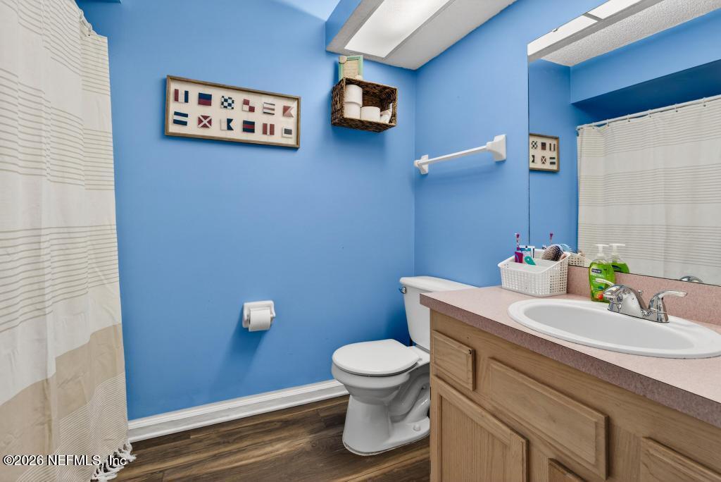 86093 Santa Barbara Street Yulee, FL 32097 - Photo 31 of 51 a bathroom with a toilet a sink and mirror