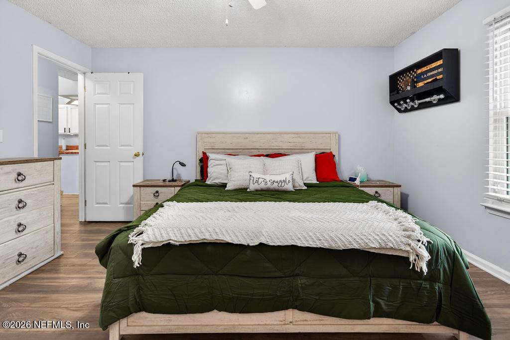 86093 Santa Barbara Street Yulee, FL 32097 - Photo 39 of 51 a bedroom with a bed a mirror on dresser and a window