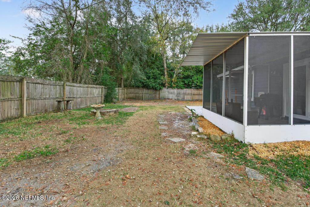 86093 Santa Barbara Street Yulee, FL 32097 - Photo 51 of 51 a backyard of a house with plants and wooden fence