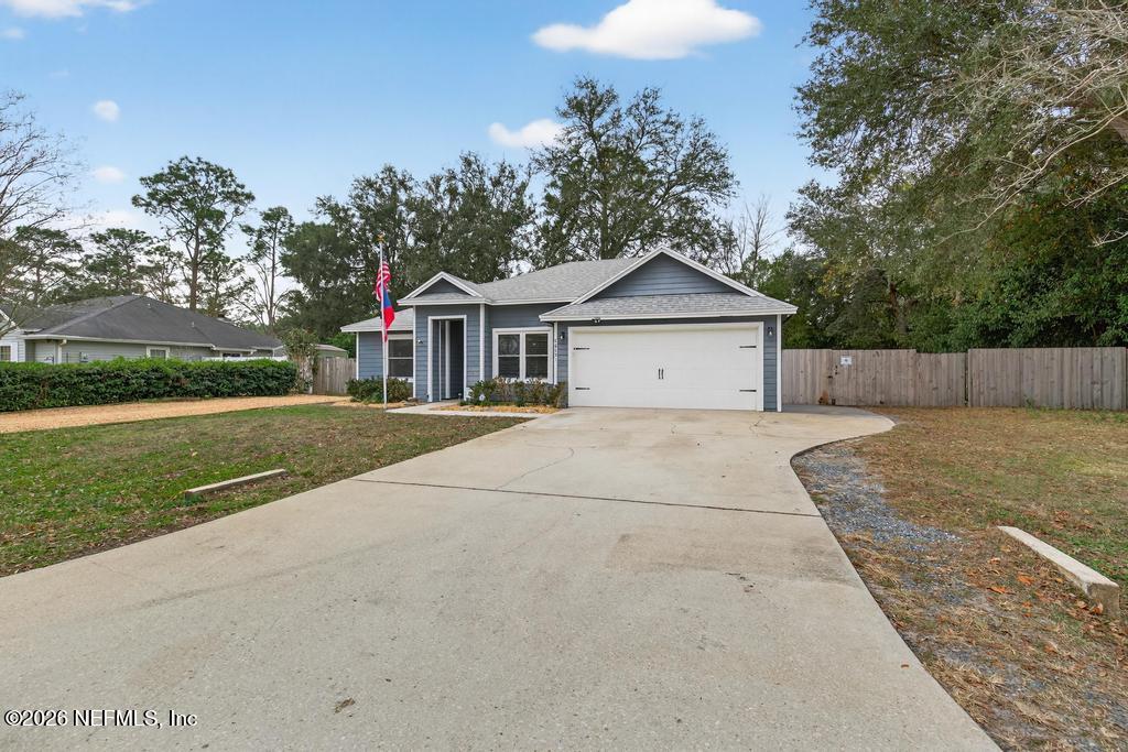 86093 Santa Barbara Street Yulee, FL 32097 - Photo 6 of 51 a front view of a house with a yard and garage