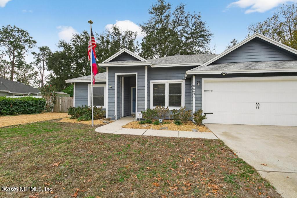86093 Santa Barbara Street Yulee, FL 32097 - Photo 10 of 51 a front view of a house with a yard and garage