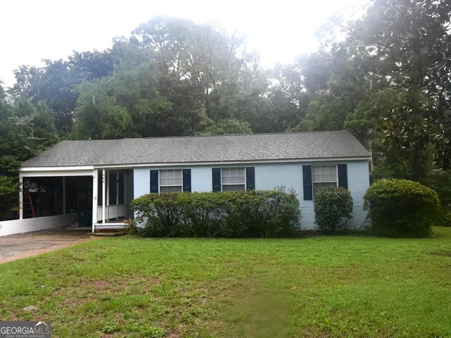 a front view of a house with yard and green space