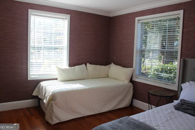 a bedroom with two beds and wooden floor