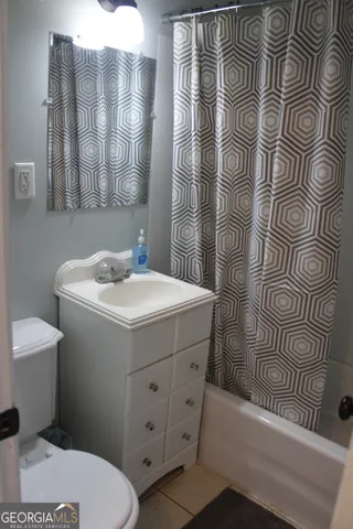 a bathroom with a sink and mirror with toilet