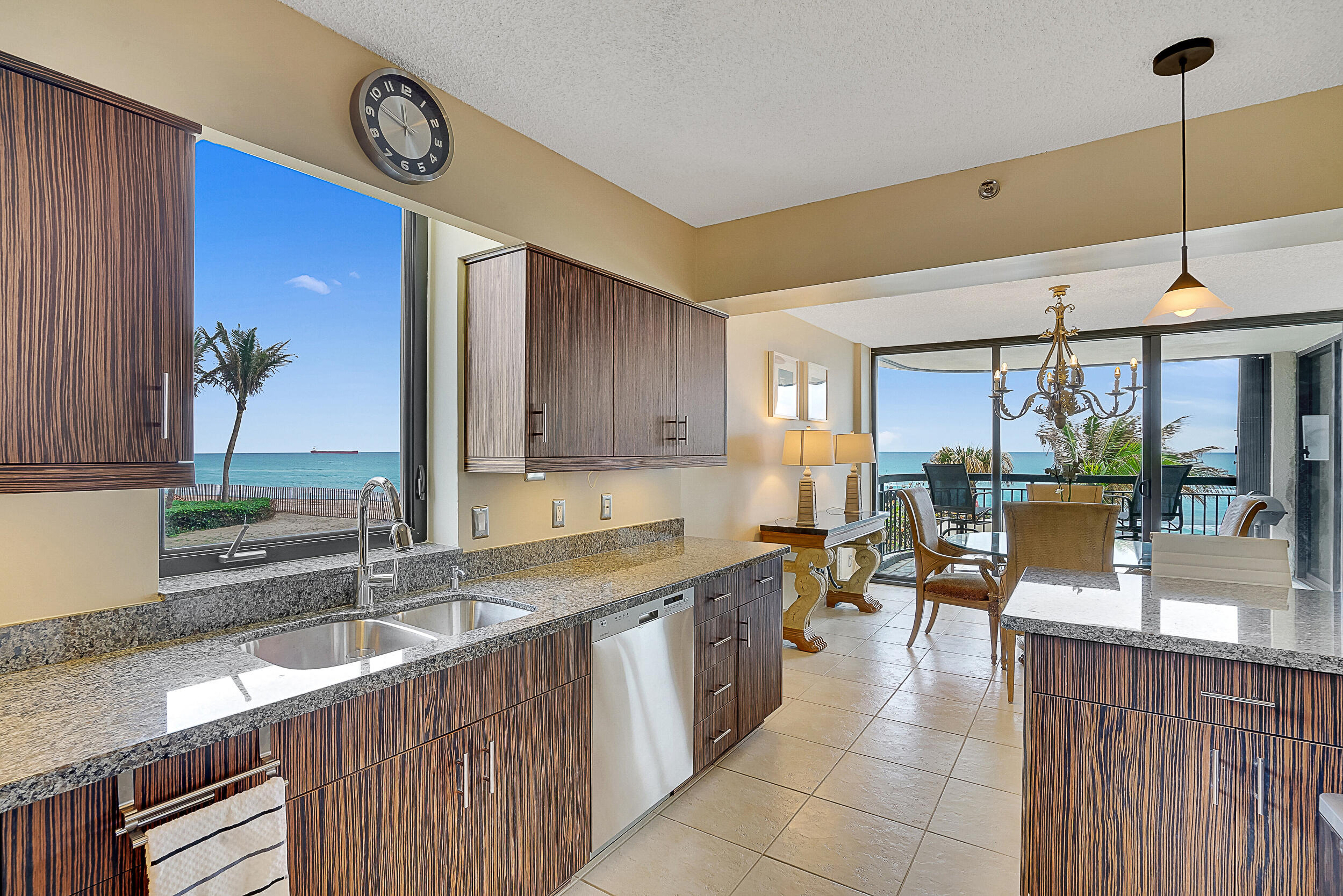 a kitchen with granite countertop a sink a counter top space and living room view
