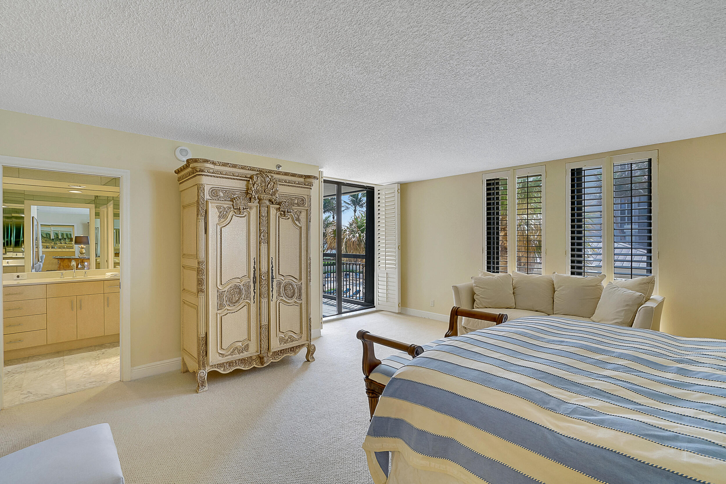 5380 North Ocean Drive, Unit 2I Singer Island, FL 33404 - Photo 12 of 32 a bedroom with a bed and a chandelier