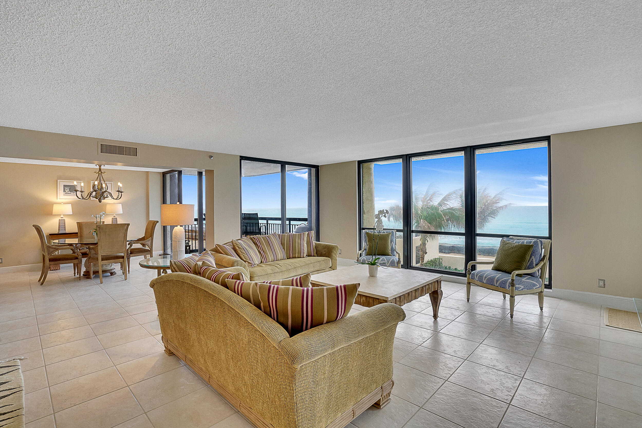 5380 North Ocean Drive, Unit 2I Singer Island, FL 33404 - Photo 5 of 32 a living room with couches and a dining table with kitchen view