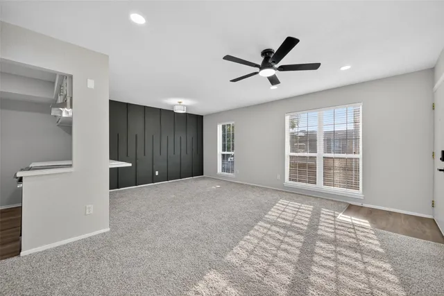 a view of a livingroom with a ceiling fan and window