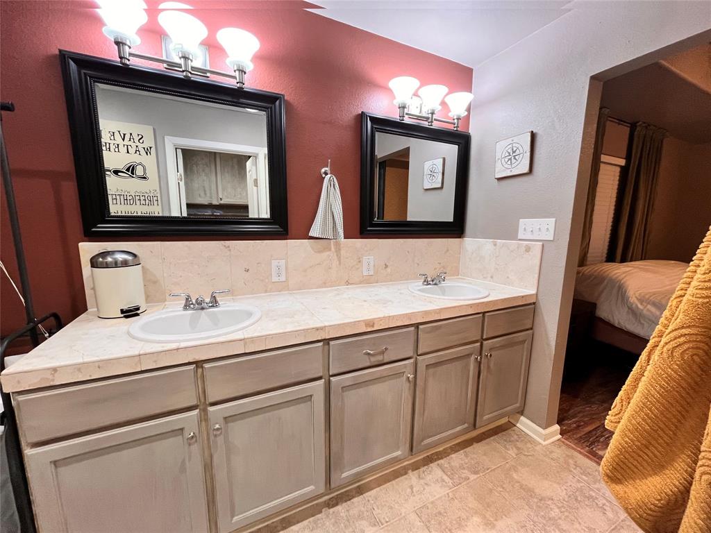 420 Sessums Road Springtown, TX 76082 - Photo 21 of 40 Master bathroom featuring double vanity, ensuite bath, and backsplash