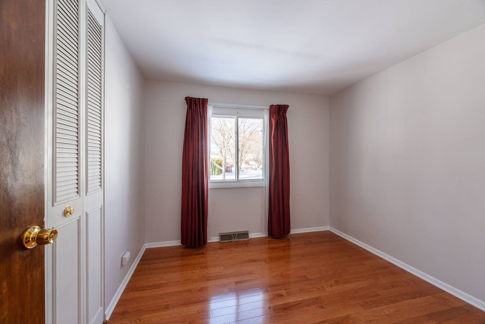 795 Plymouth Road Hoffman Estates, IL 60192 - Photo 12 of 26 an empty room with wooden floor and windows
