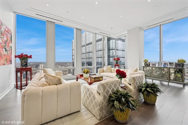 a living room with furniture and floor to ceiling windows