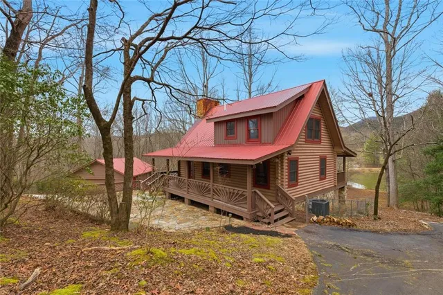 a view of an empty room with wooden floor fireplace and a window