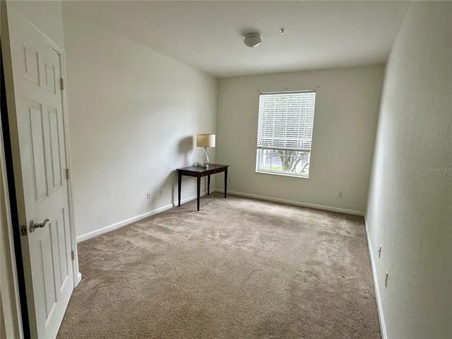 an empty room with closet and windows