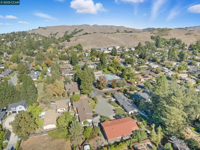 an aerial view of residential houses with outdoor space and trees