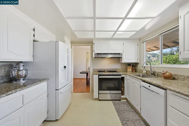 a kitchen with white cabinets and appliances