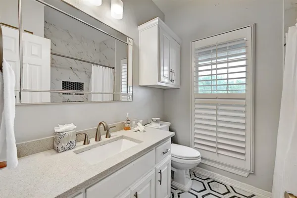 a bathroom with a sink a toilet and mirror