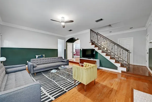 a living room with furniture and a wooden floor