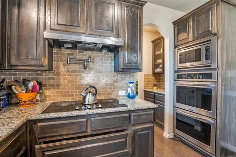 a kitchen with stainless steel appliances granite countertop a stove and a sink