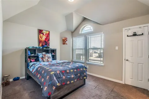 a bedroom with a bed a dresser and a window