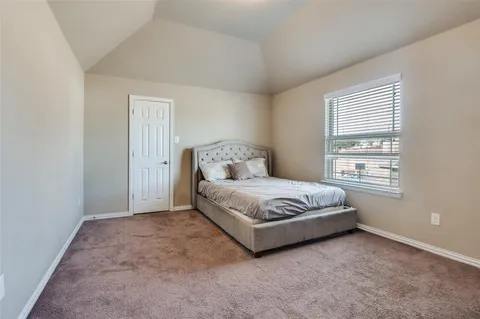 a spacious bedroom with a bed and a window